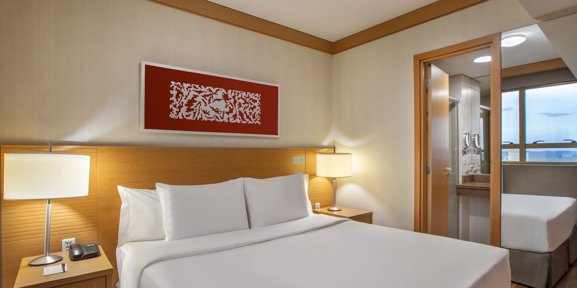 a bed with white sheets and a lamp