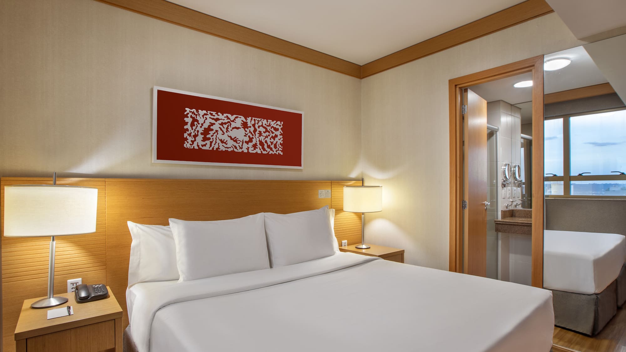 a bed with white sheets and a lamp