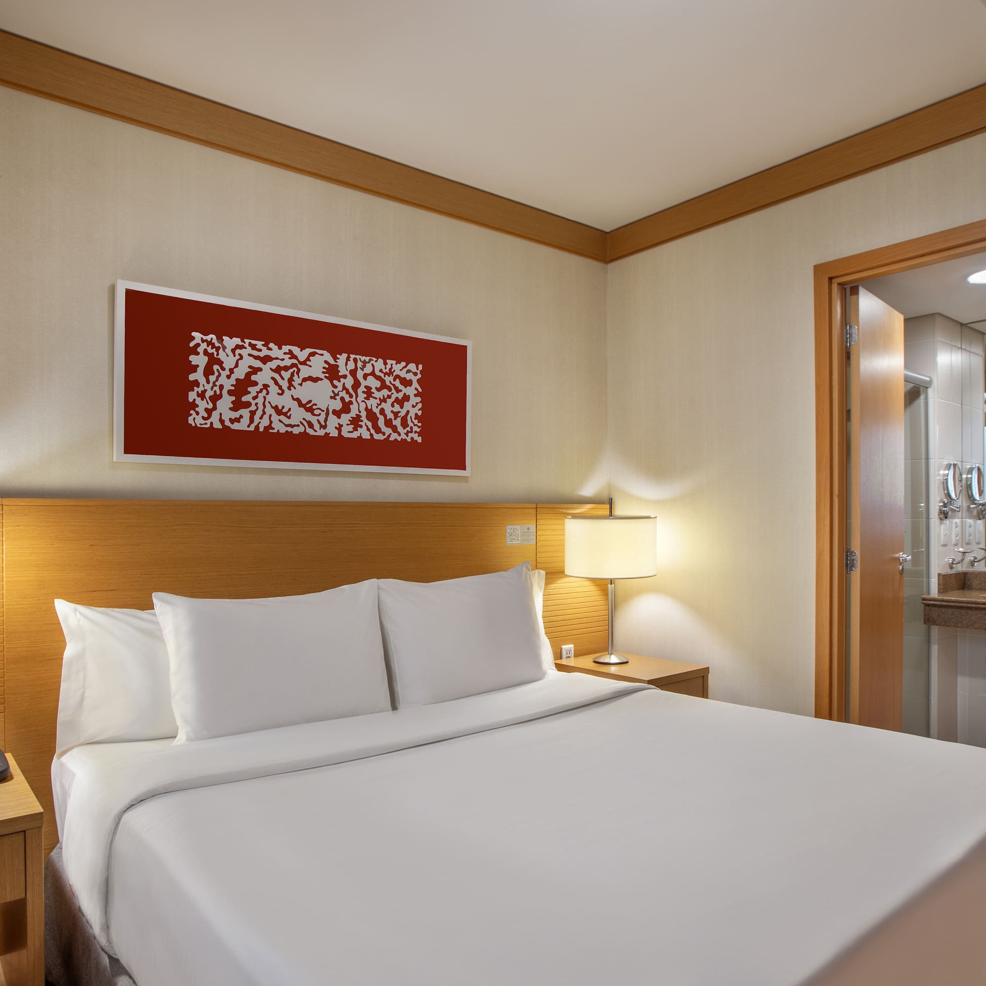 a bed with white sheets and a lamp