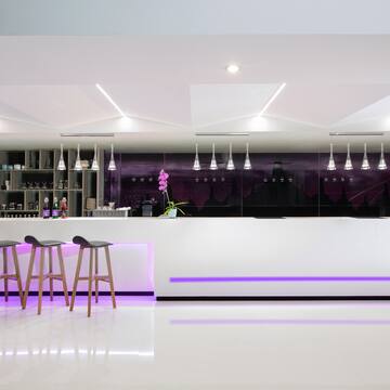 a bar counter with stools and lights