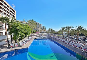 a pool with lounge chairs and trees