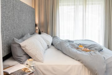 a bed with a tray of coffee and a plate of food