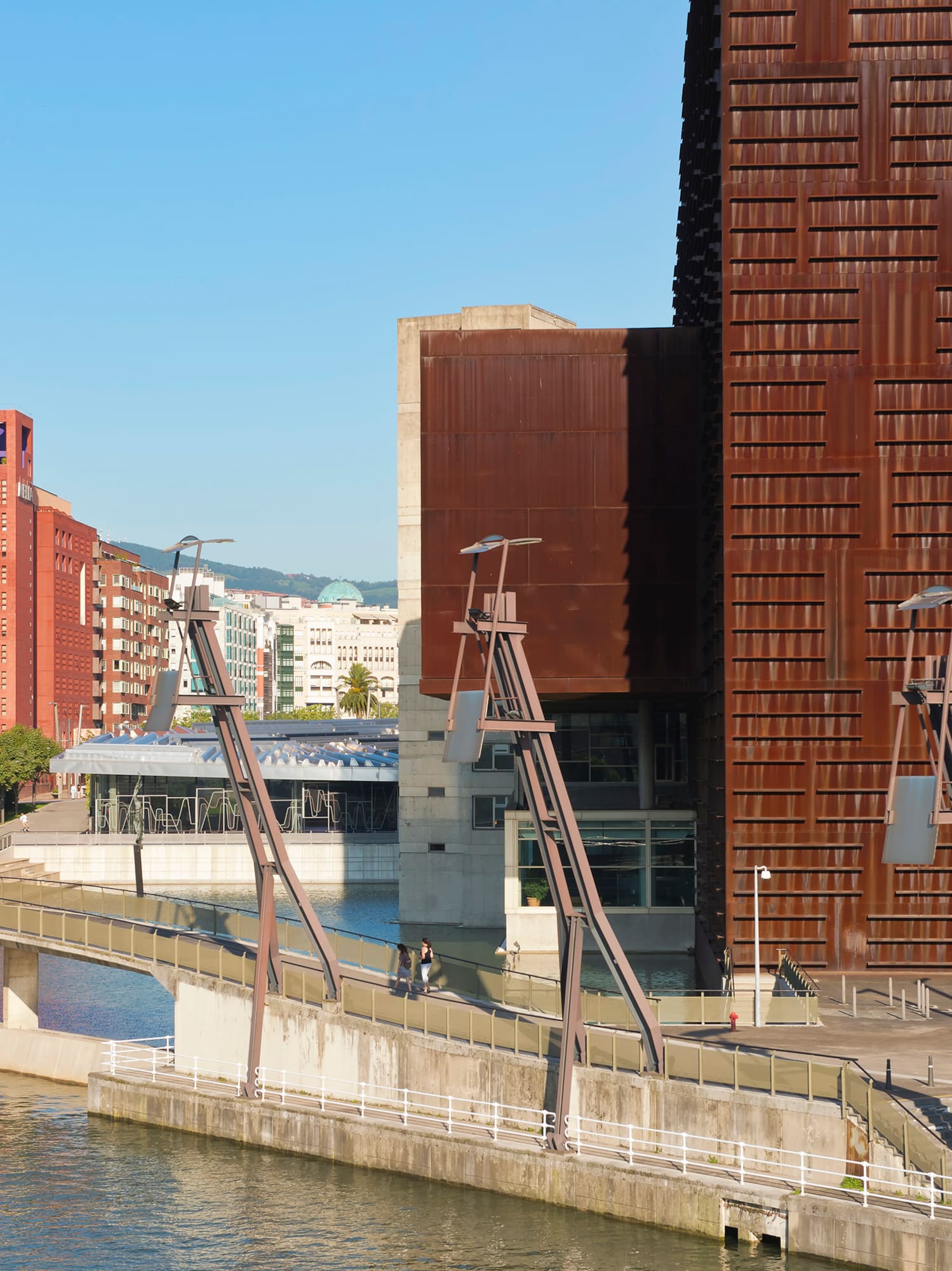 a bridge over water with a building in the background