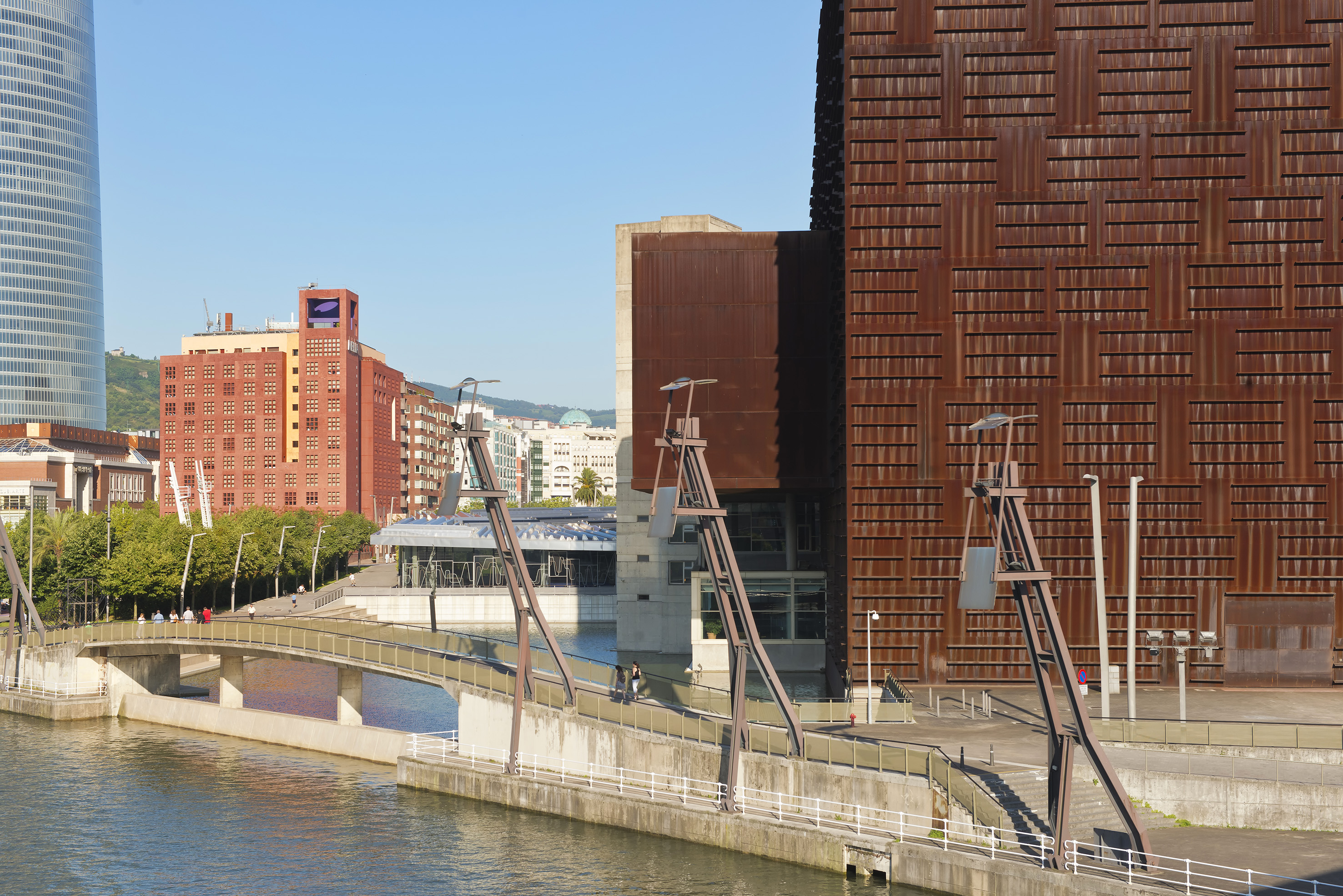 Bilbao cityscape: Azkuna Zentroa, Iberdrola Tower, river, pedestrian bridge.