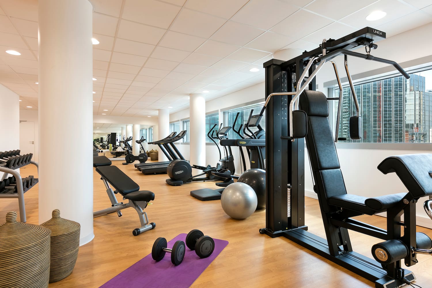 a room with exercise equipment and a large window