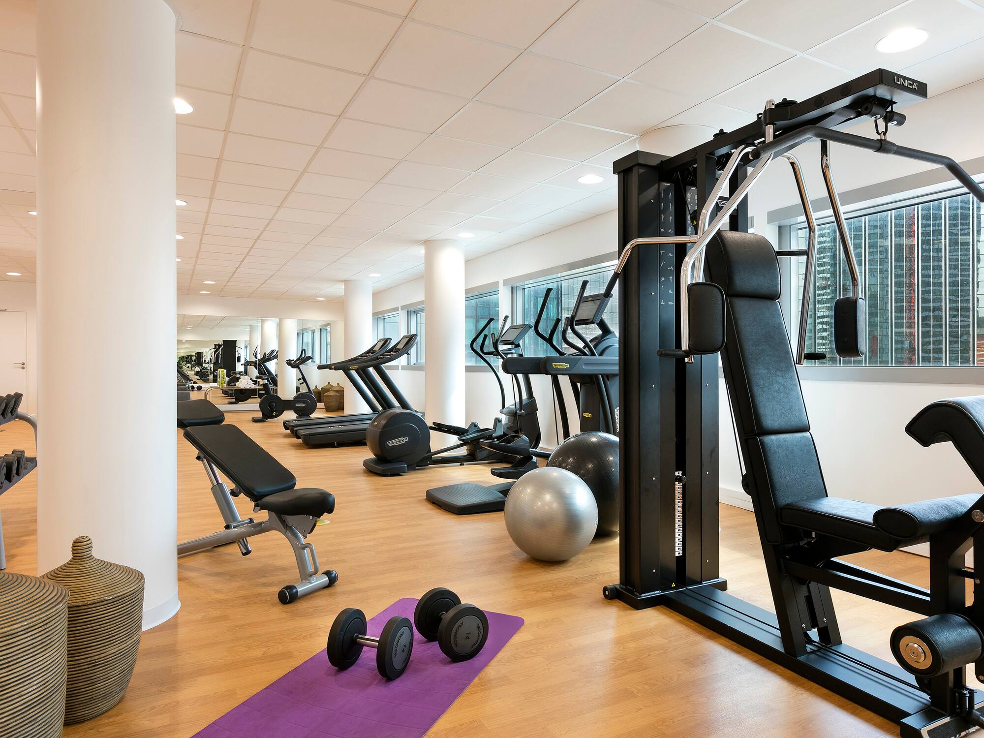 a room with exercise equipment and a large window