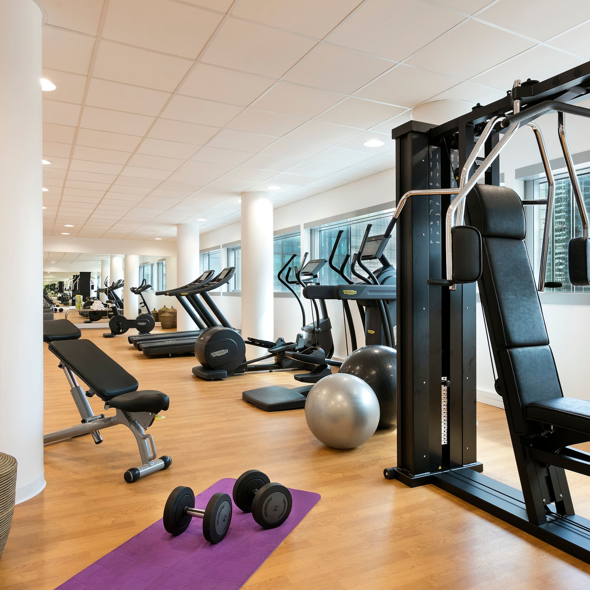 a room with exercise equipment and a large window
