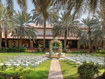 a wedding ceremony with chairs and a building