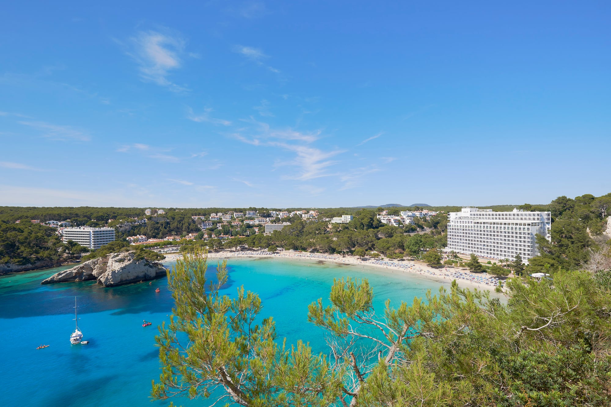 Cala Galdana beach, Menorca: turquoise water, sandy shore, resort hotels.