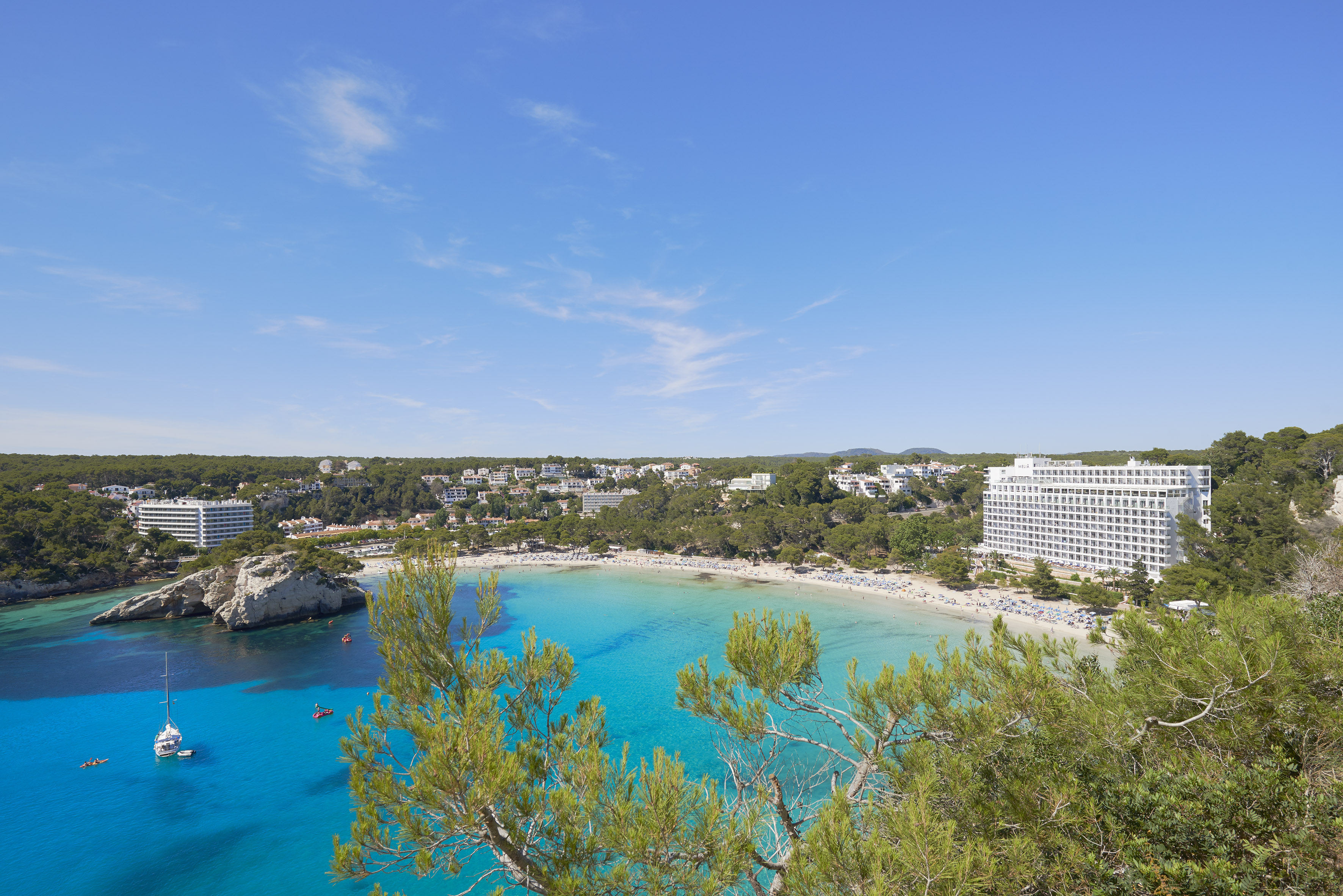 Cala Galdana beach, Menorca: turquoise water, sandy shore, resort hotels.