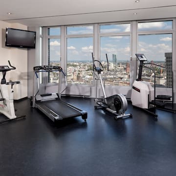 a room with exercise equipment and a view of a city
