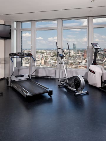 a room with exercise equipment and a view of a city
