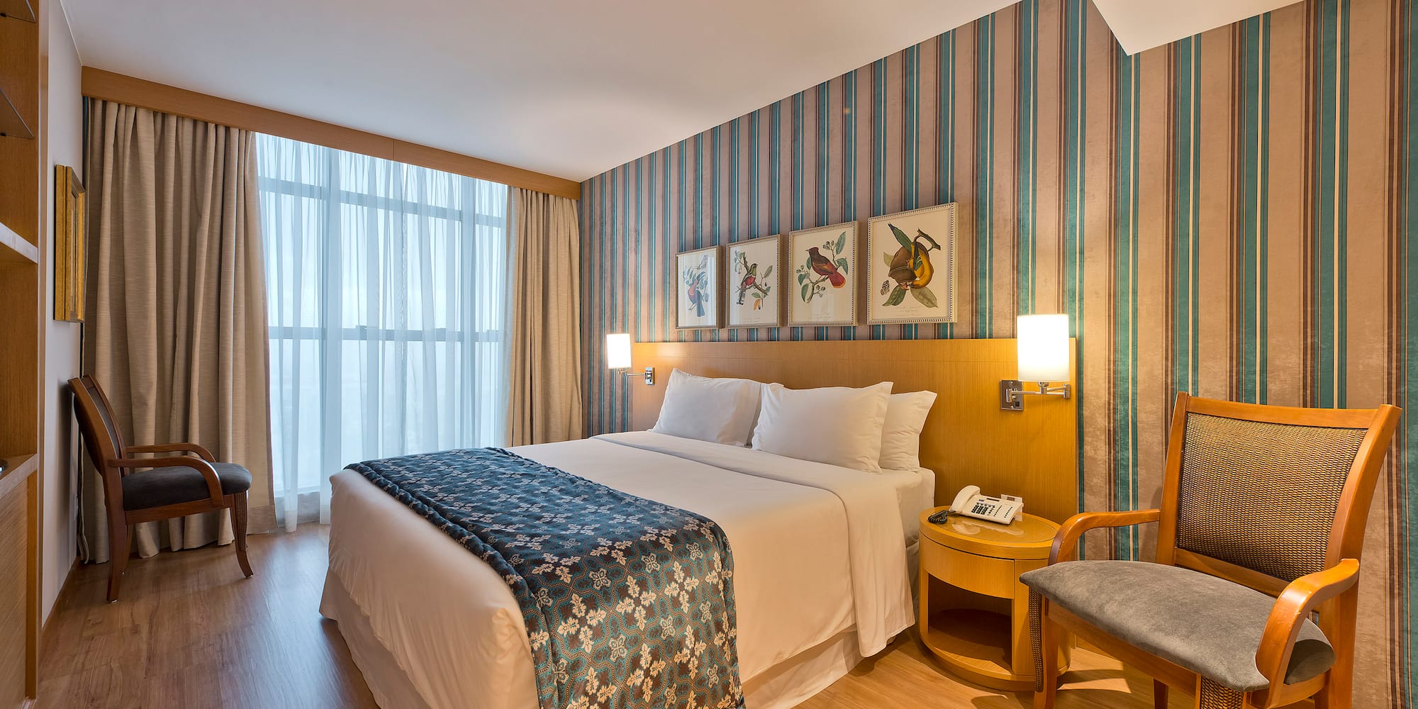 a room with a bed and chairs