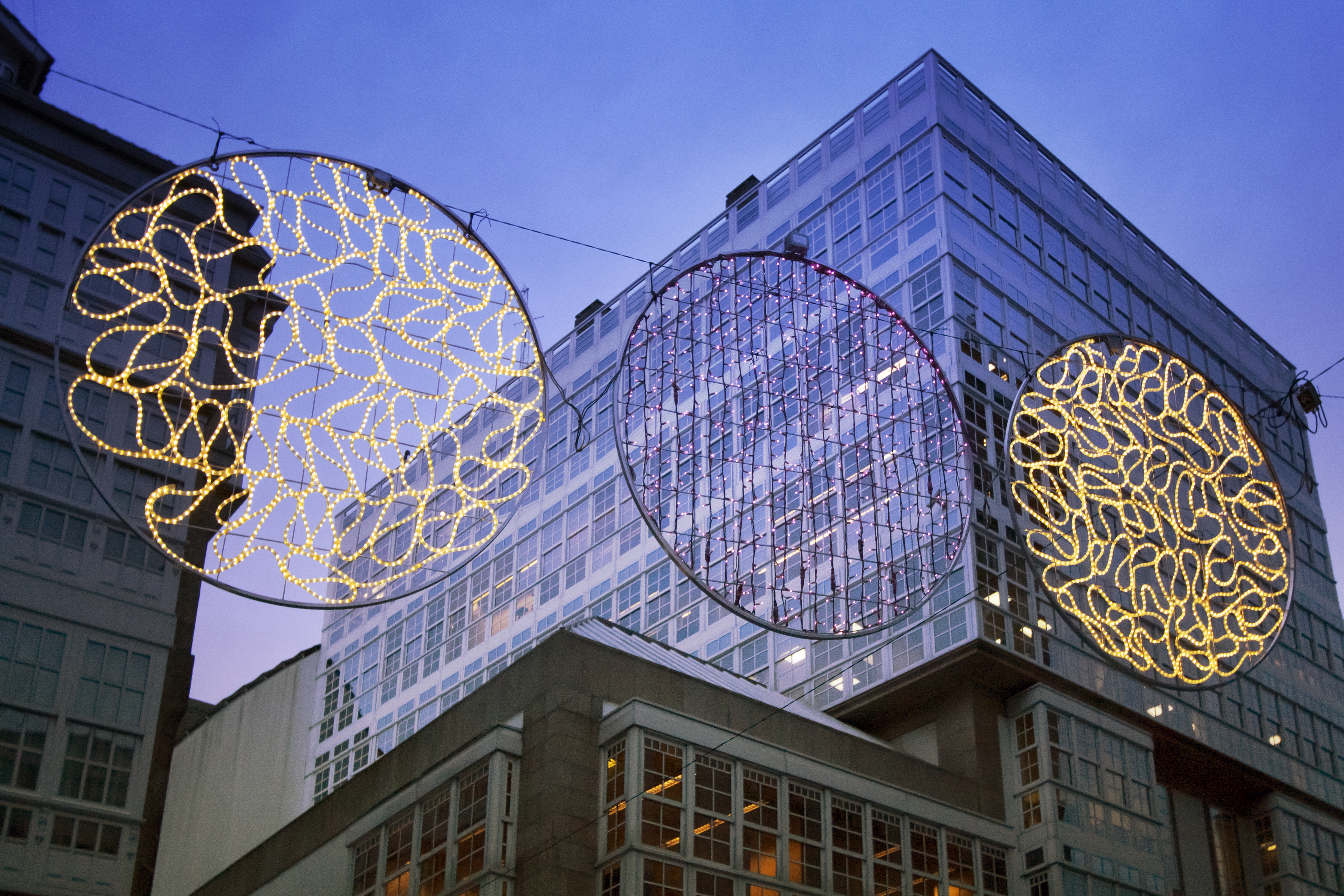 a group of lights from a wire in front of a building