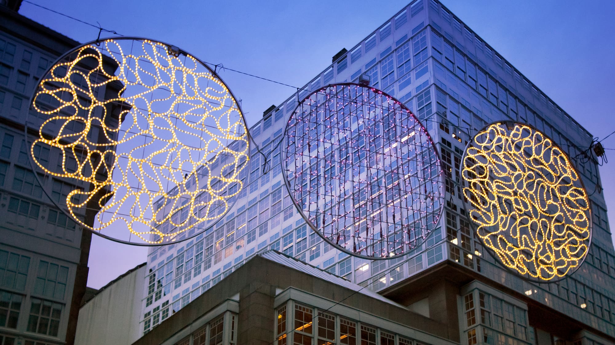 a group of lights from a wire in front of a building