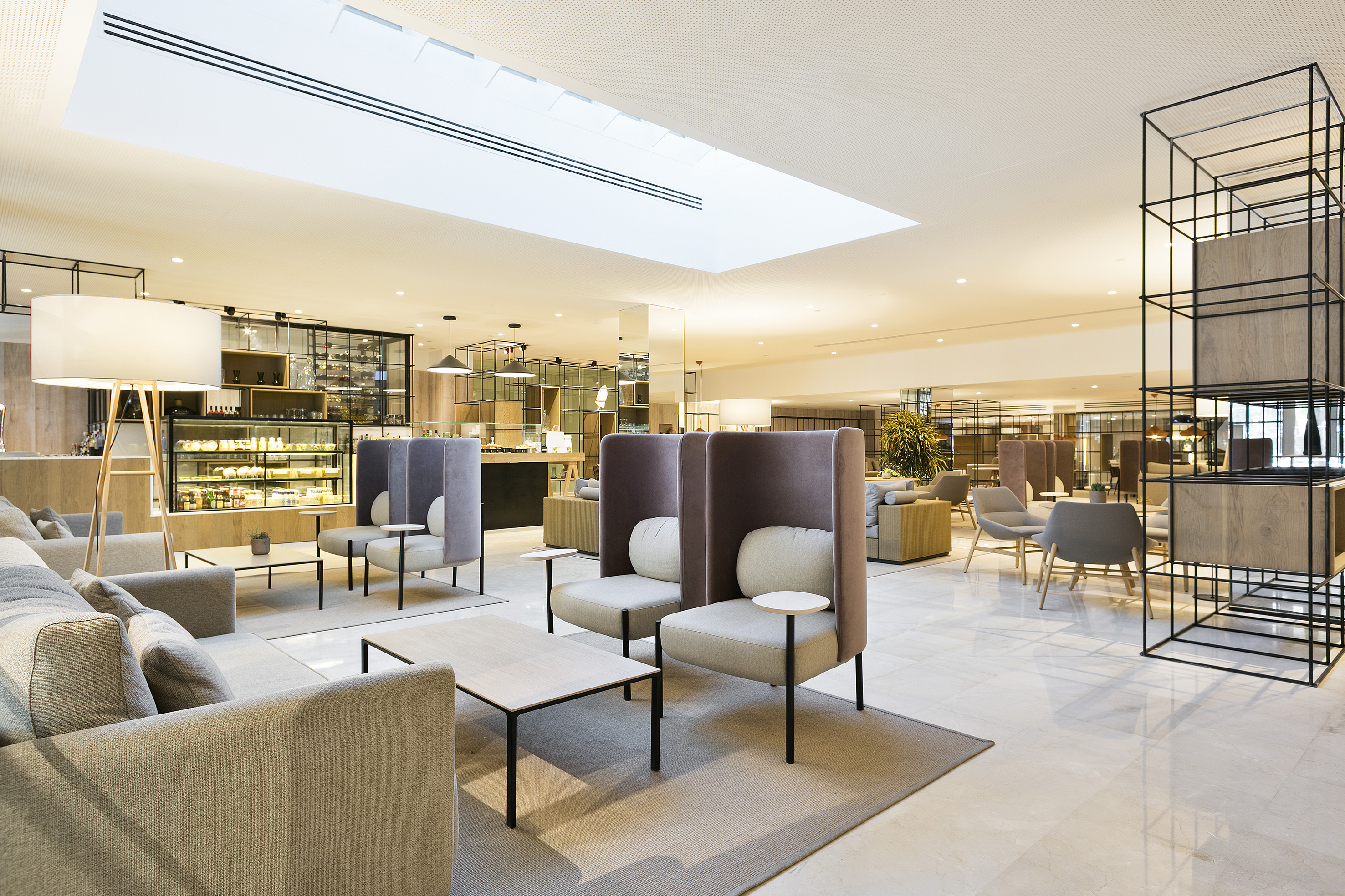 Bright, modern hotel lounge with contemporary seating, cafe bar, and skylight.