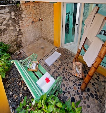 a shower with a green bench and towels on it