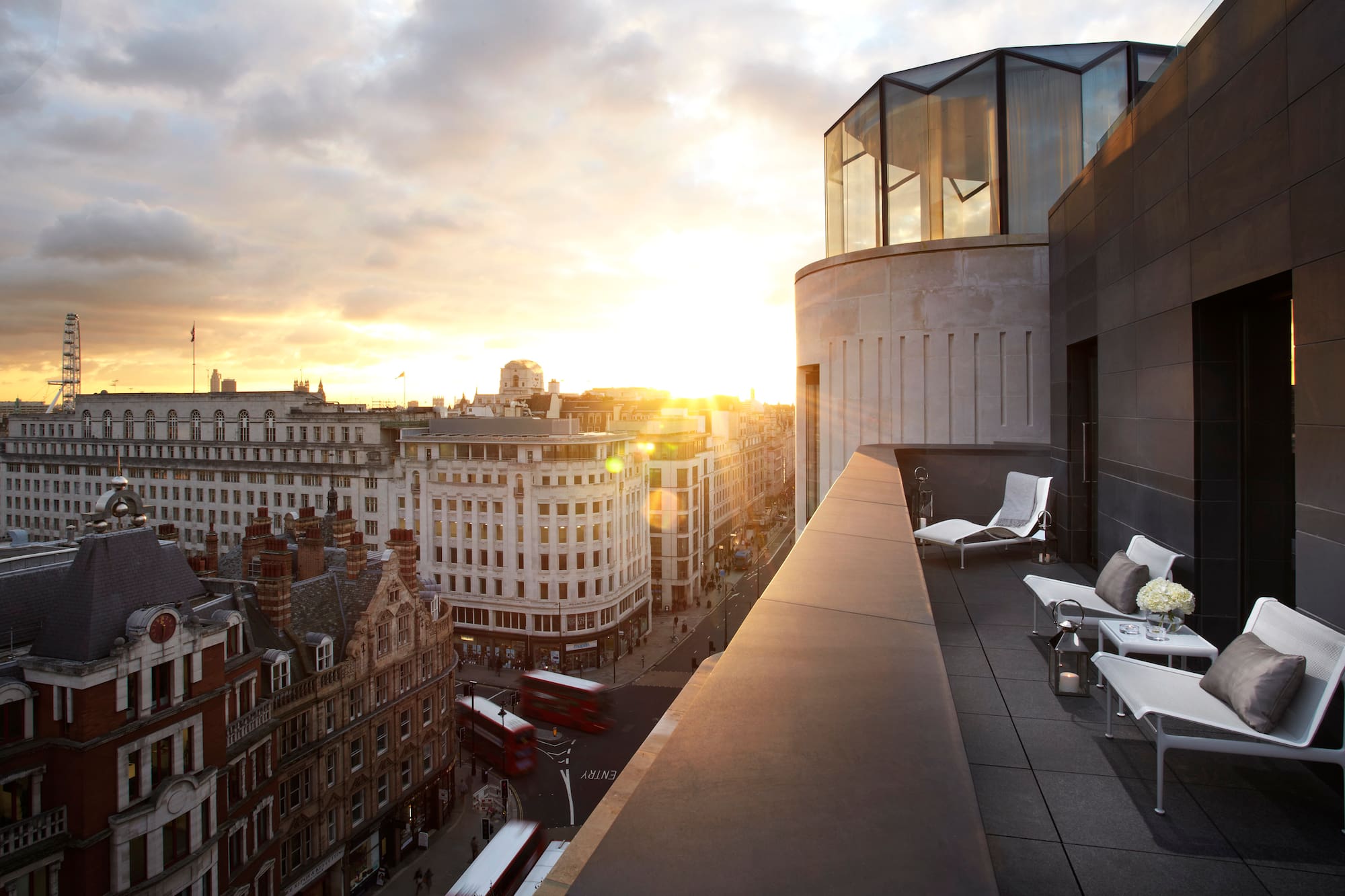 a rooftop view of a city with a large glass balcony