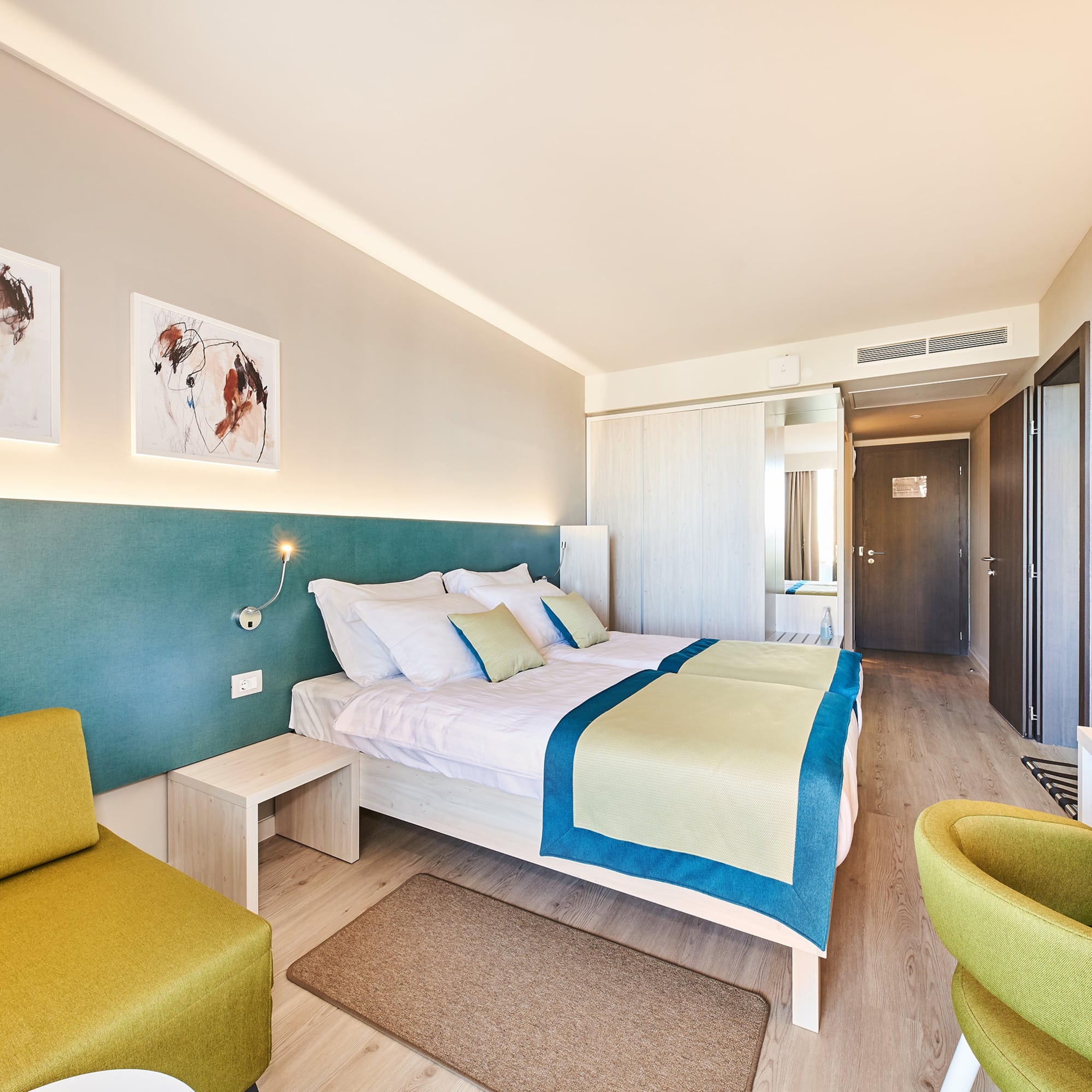 a room with a bed and chairs