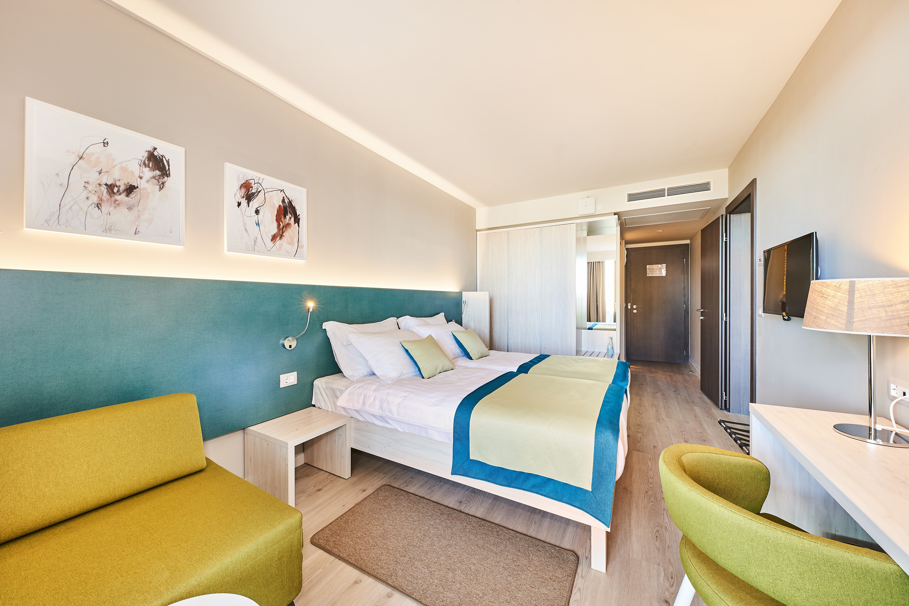 a room with a bed and chairs