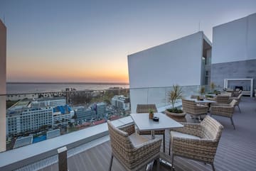 a table and chairs on a balcony overlooking a city