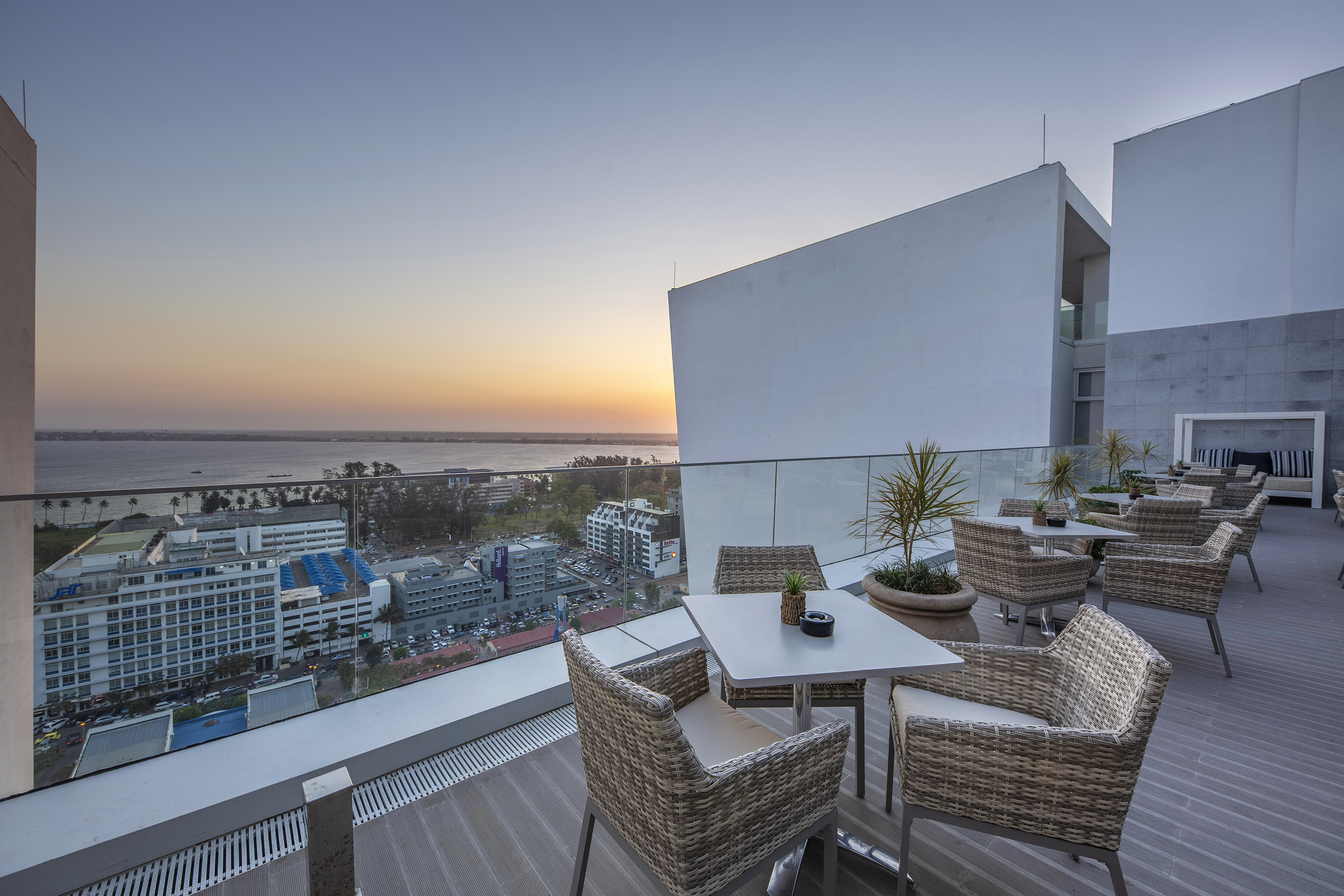Hotel rooftop dining terrace overlooking city, ocean, and sunset. - Sky Bar, Aperitieven - Meliá Maputo Sky, Maputo