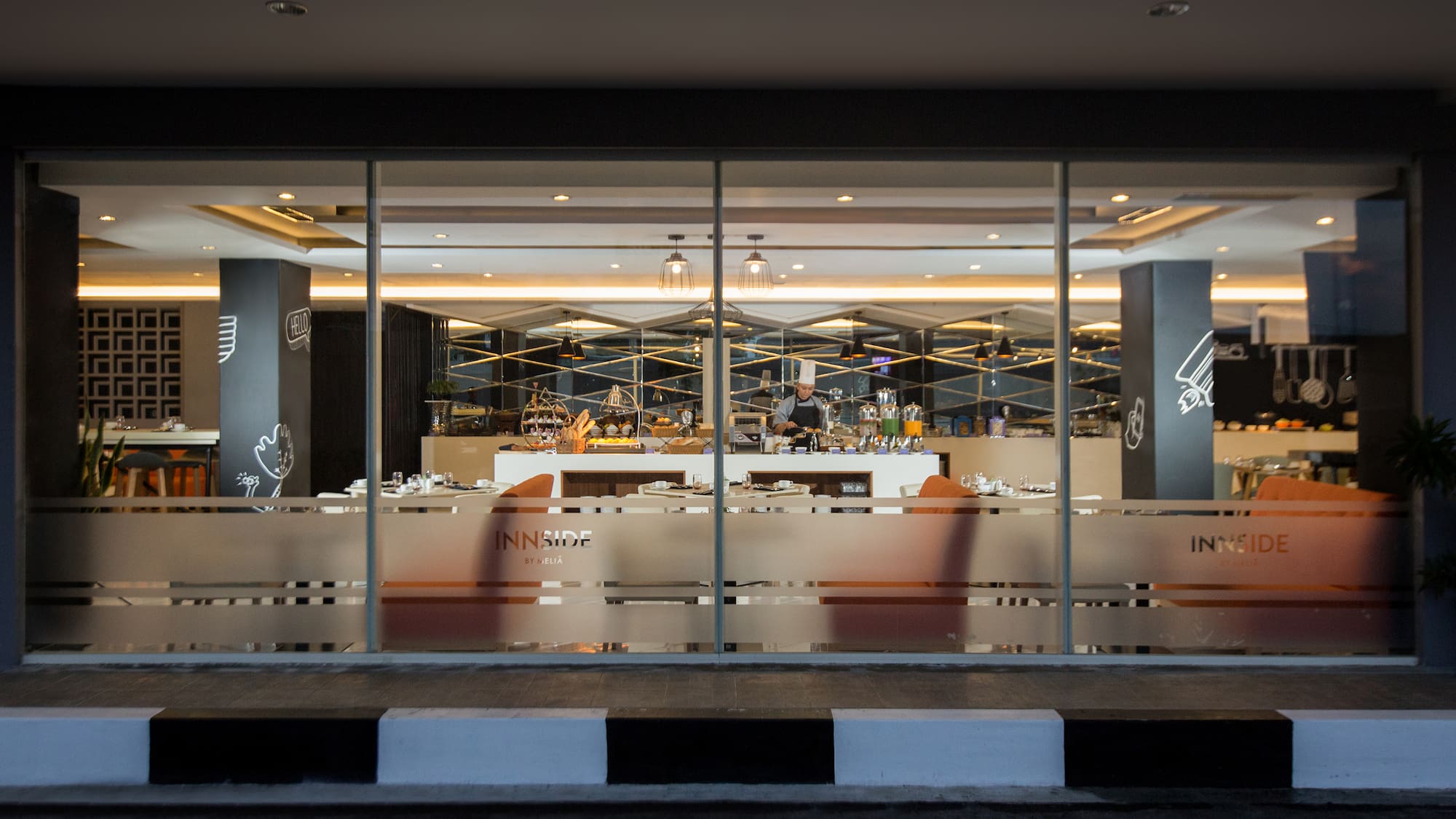 a glass wall with a bar and a person behind it