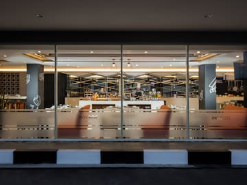 a glass wall with a bar and a person behind it