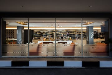 a glass wall with a bar and a person behind it