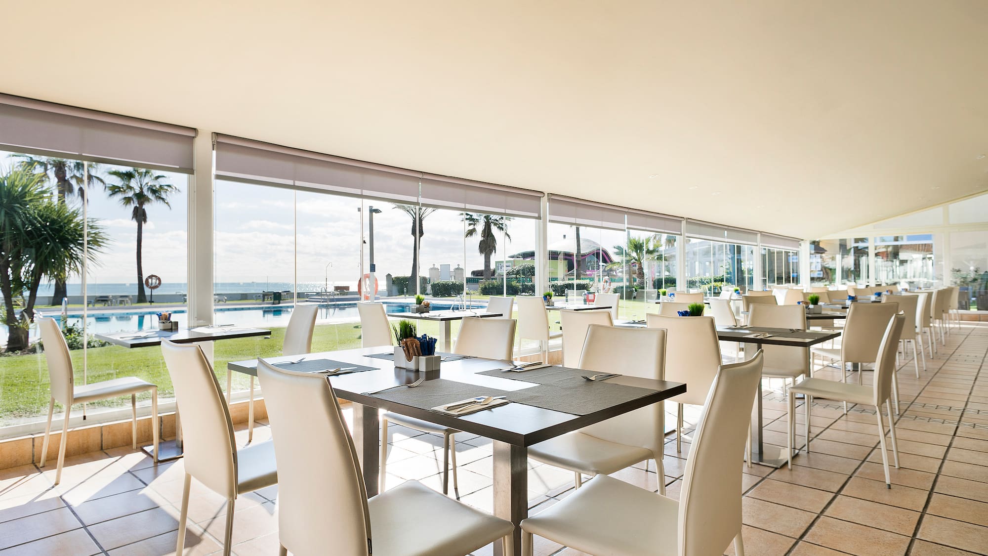 a room with white chairs and tables