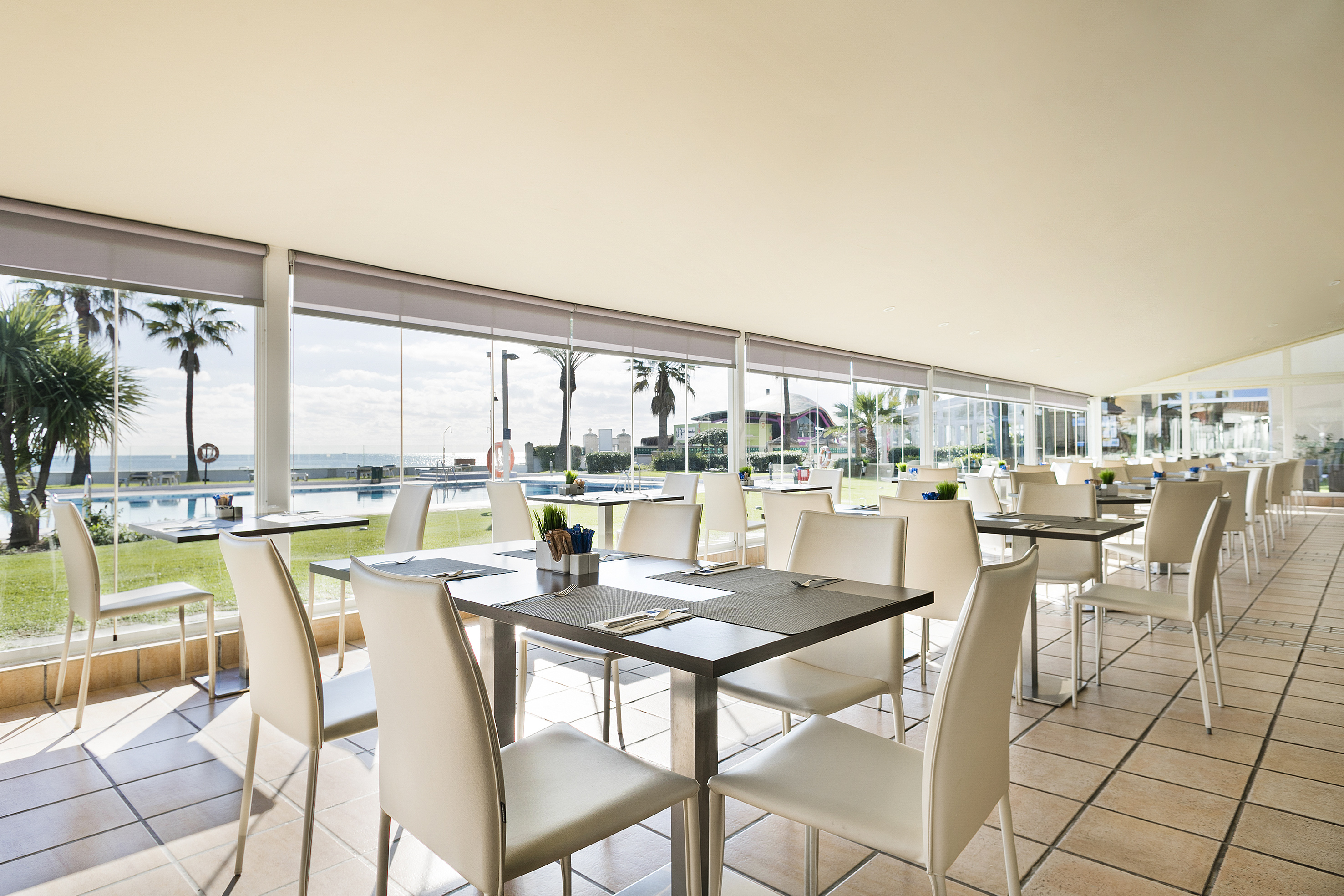a room with white chairs and tables