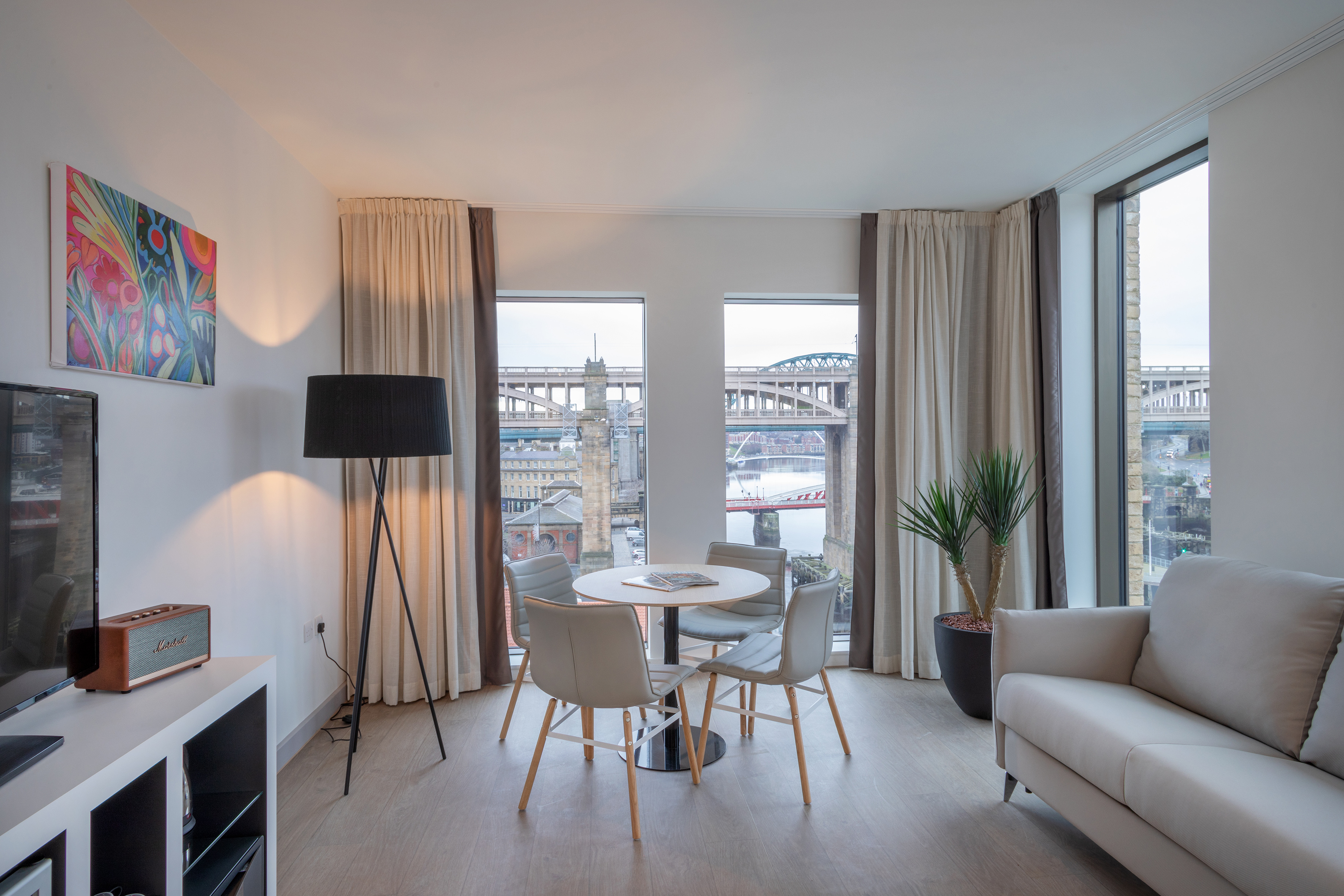 Modern apartment living room with Newcastle bridge view and dining area.