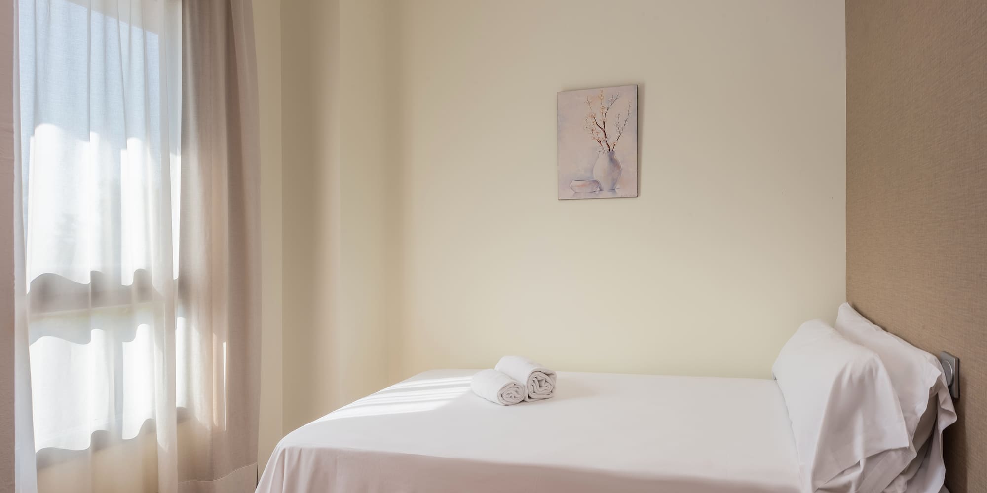 a bed with white sheets and towels on it