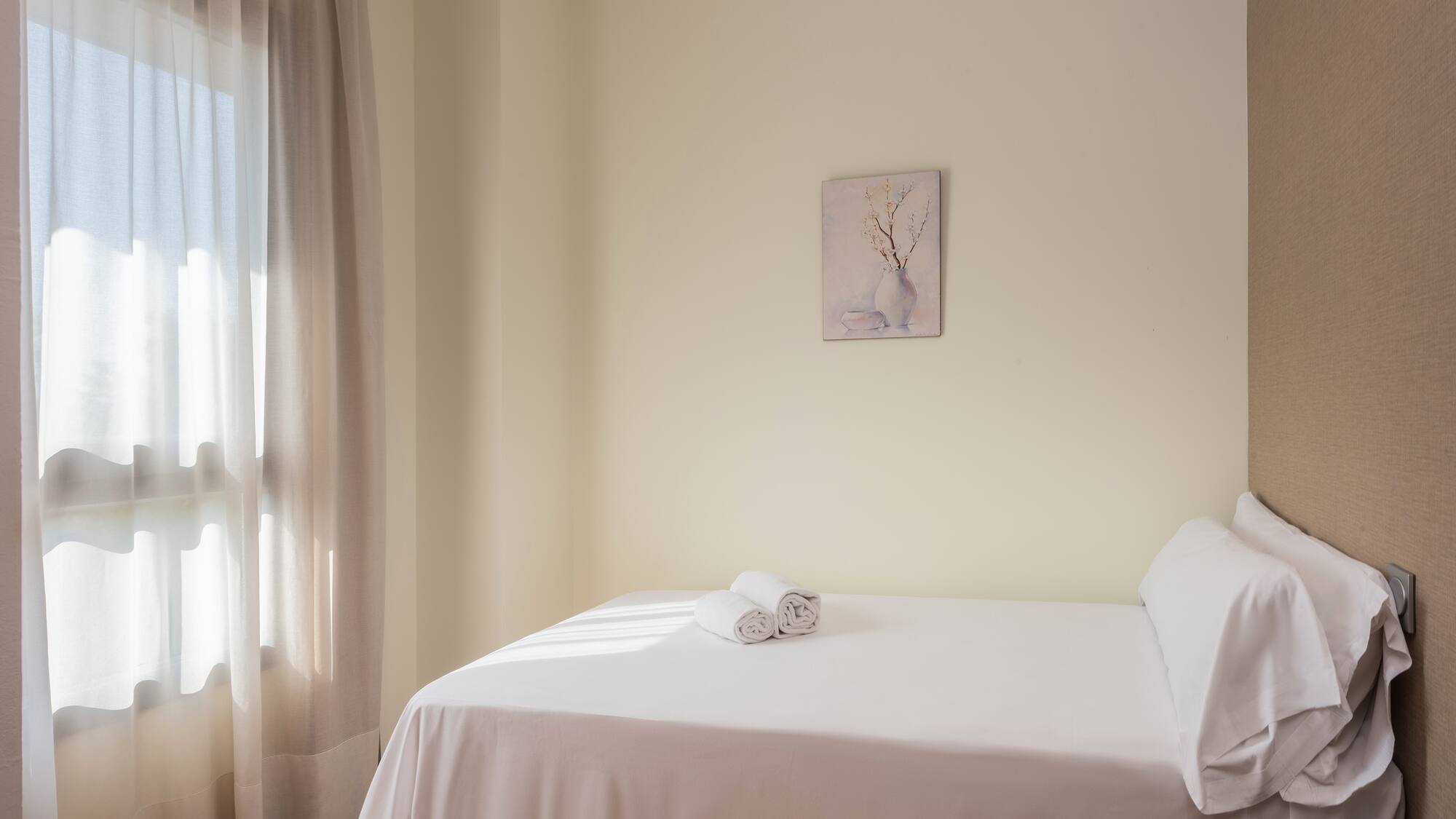 a bed with white sheets and towels on it