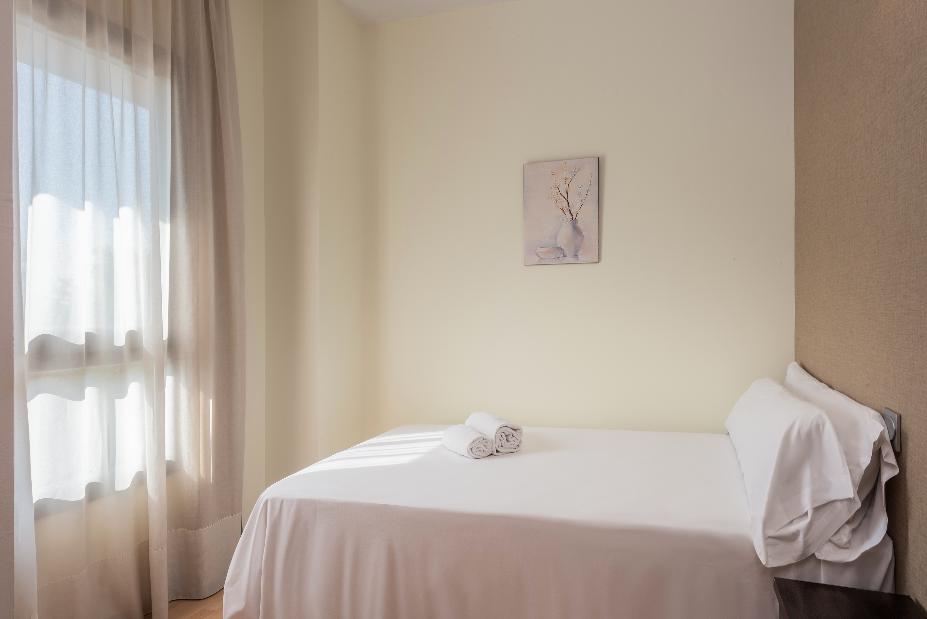 a bed with white sheets and towels on it