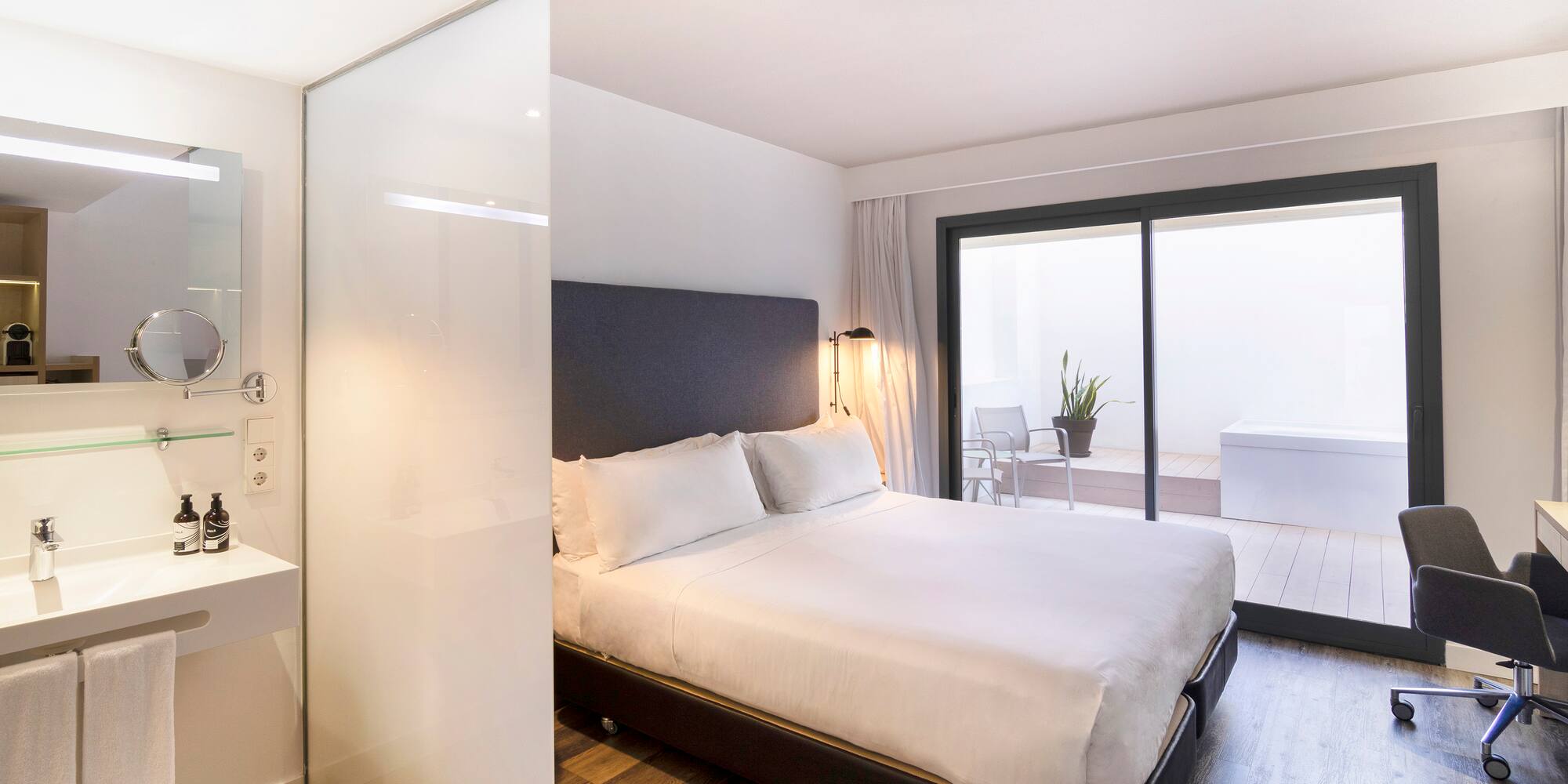 a bedroom with a glass wall and a bed