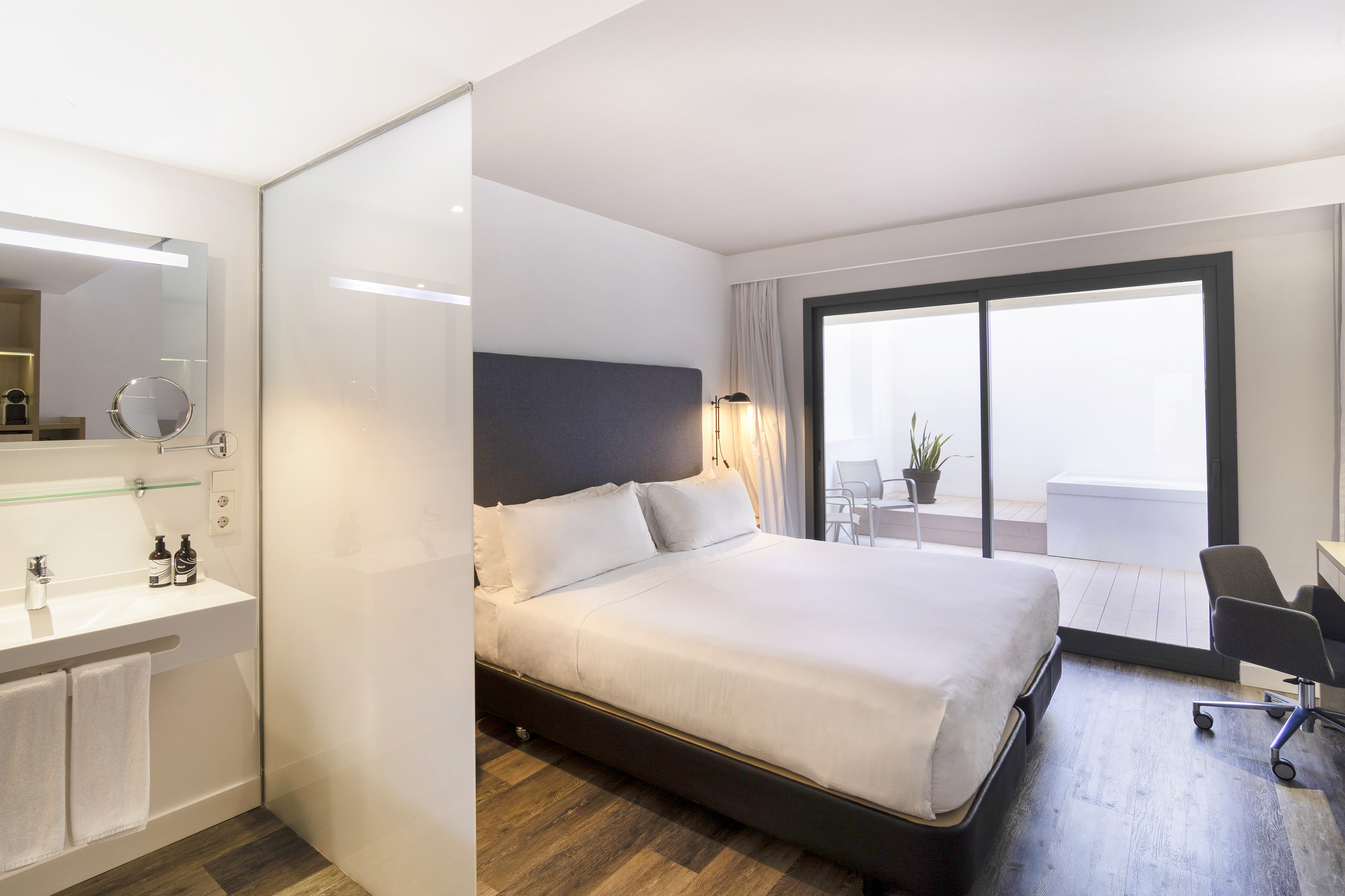 a bedroom with a glass wall and a bed