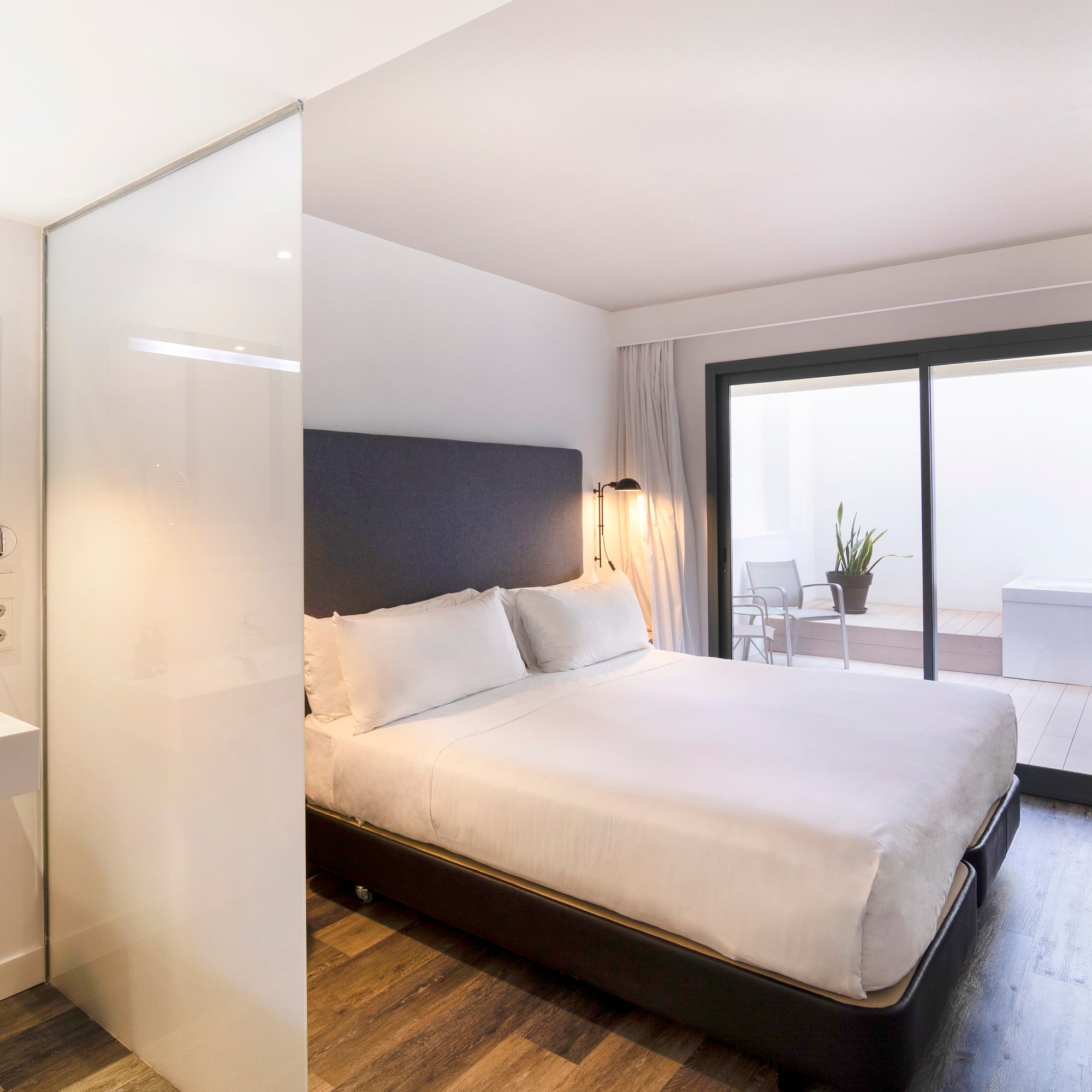 a bedroom with a glass wall and a bed