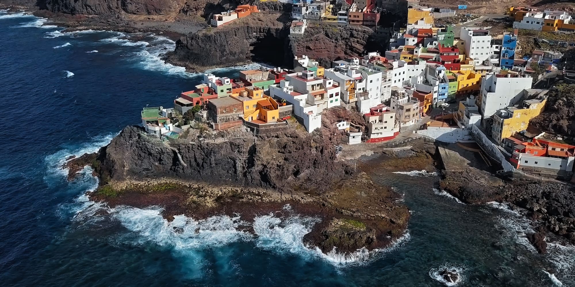 a colorful buildings on a rocky cliff by the ocean