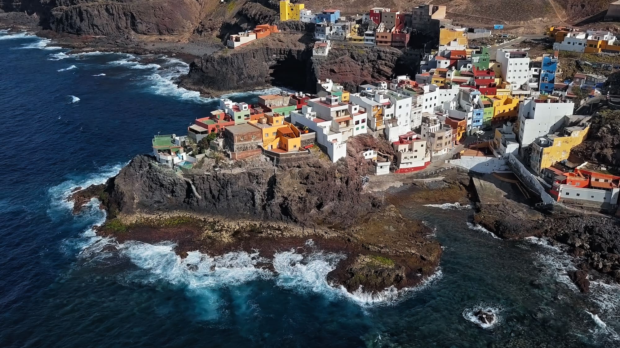a colorful buildings on a rocky cliff by the ocean
