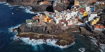 a colorful buildings on a rocky cliff by the ocean