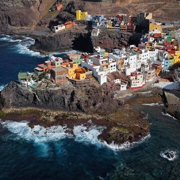 a colorful buildings on a rocky cliff by the ocean