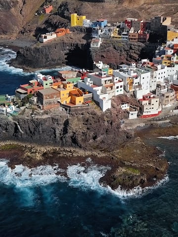 a colorful buildings on a rocky cliff by the ocean