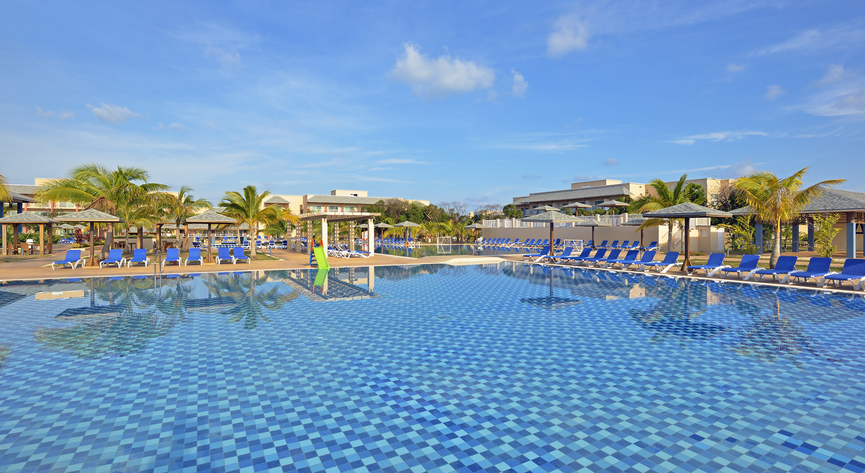 a pool with chairs and trees