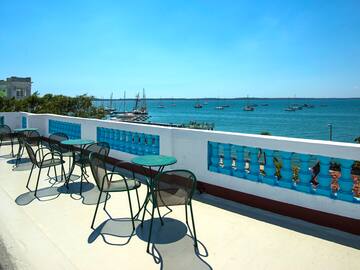 a table and chairs on a deck overlooking a body of water