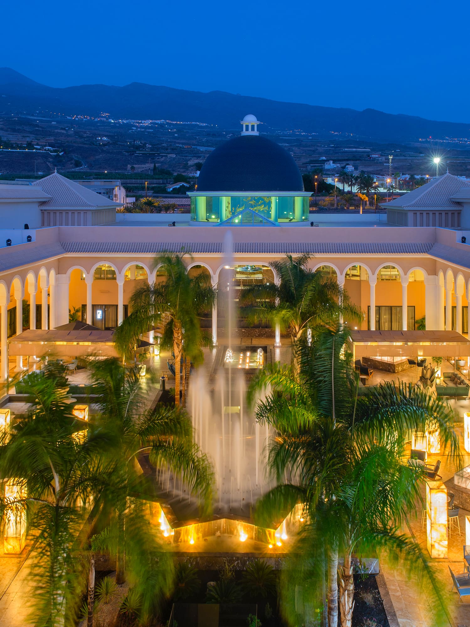 a fountain in a courtyard with palm trees