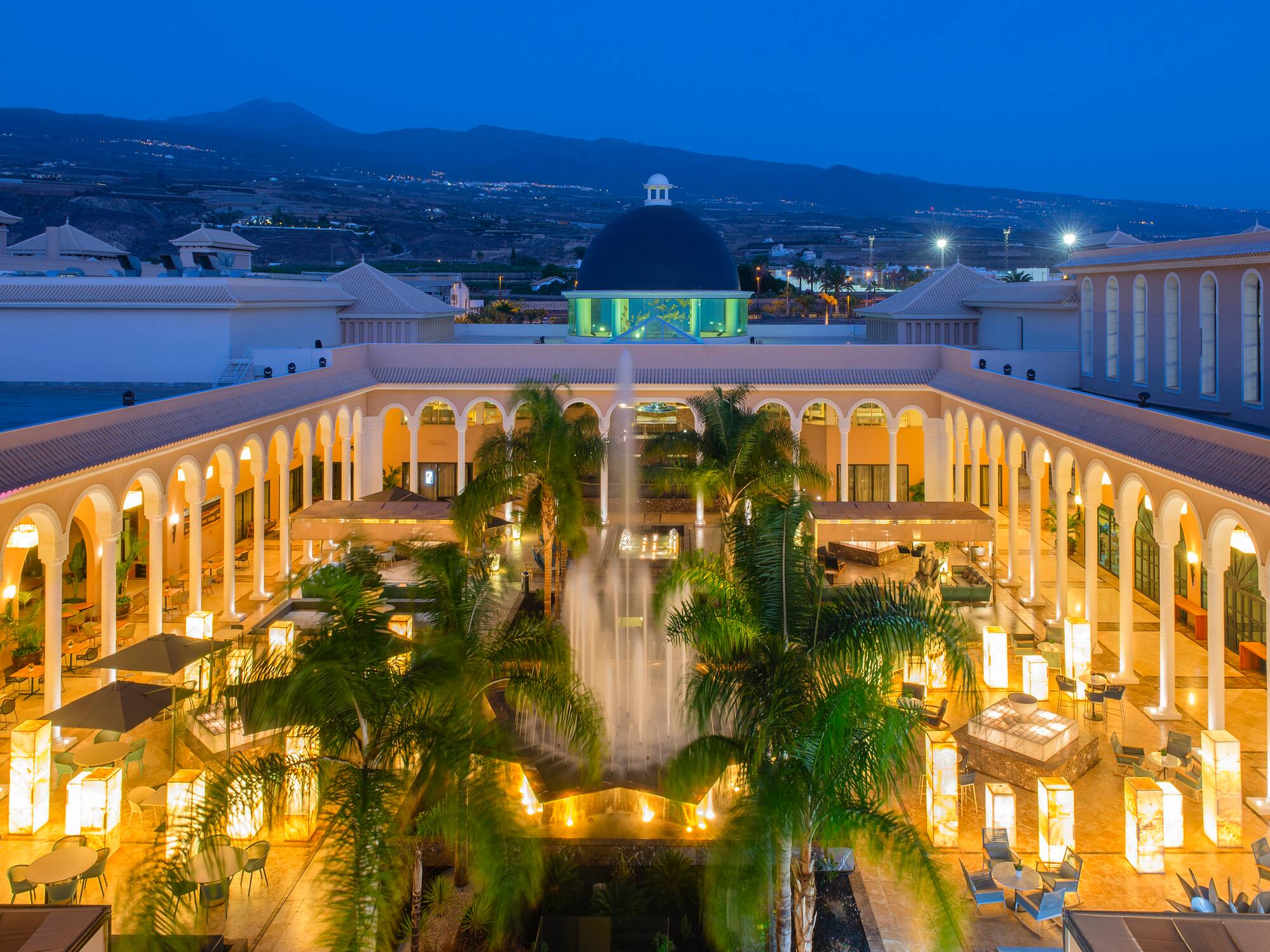 a fountain in a courtyard with trees and a dome
