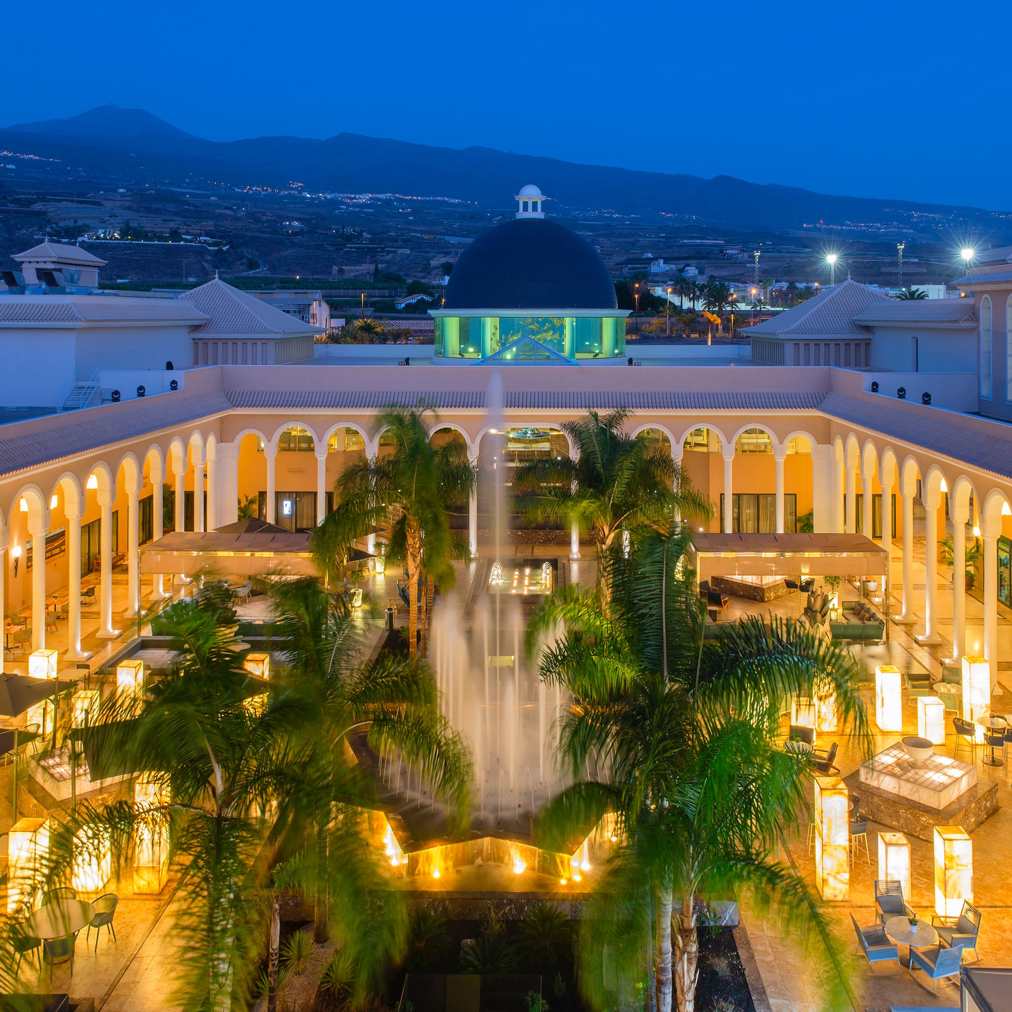 a fountain in a courtyard with palm trees