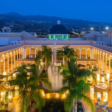 a fountain in a courtyard with trees and a dome