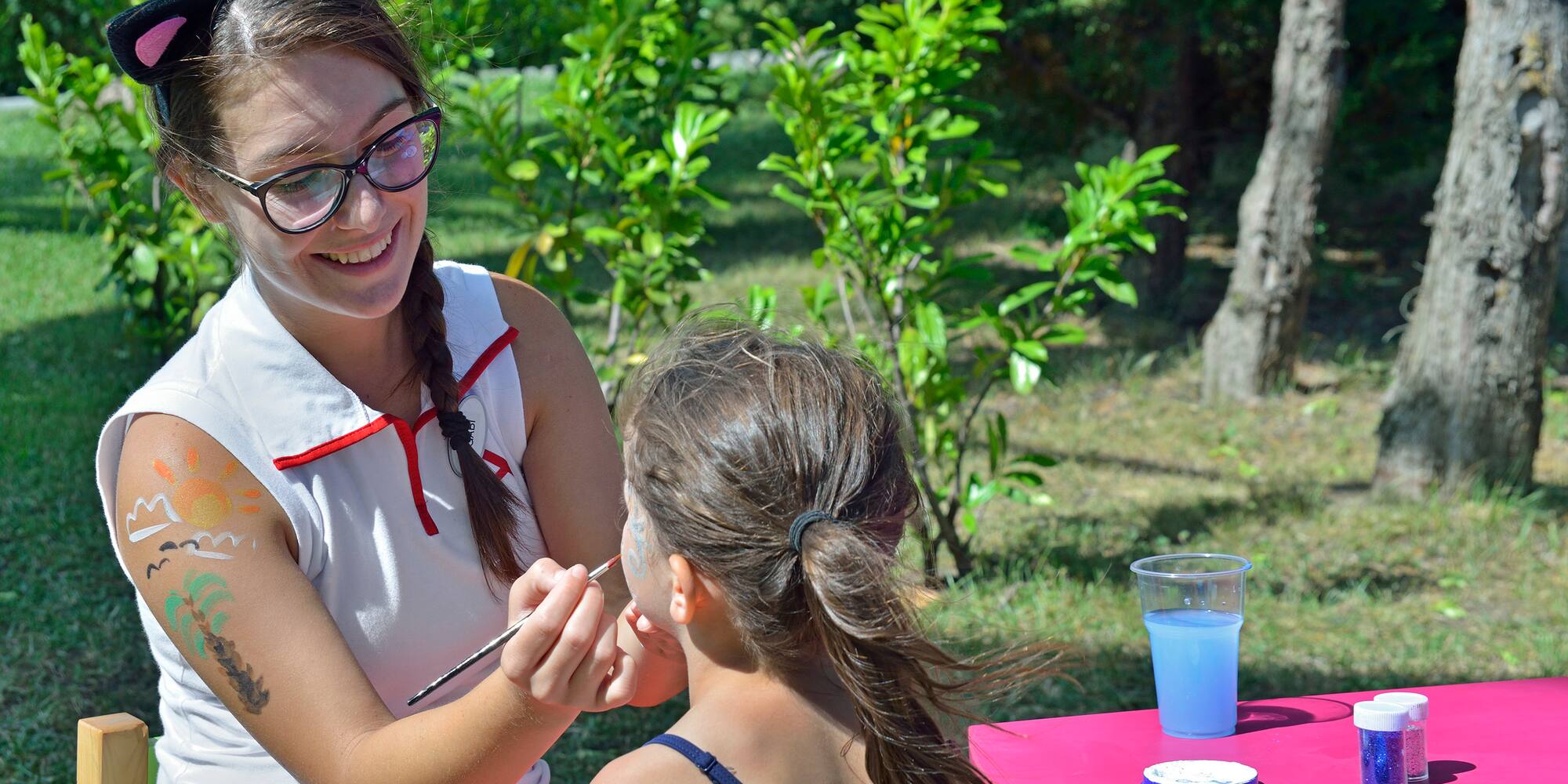 a woman painting a girl's face